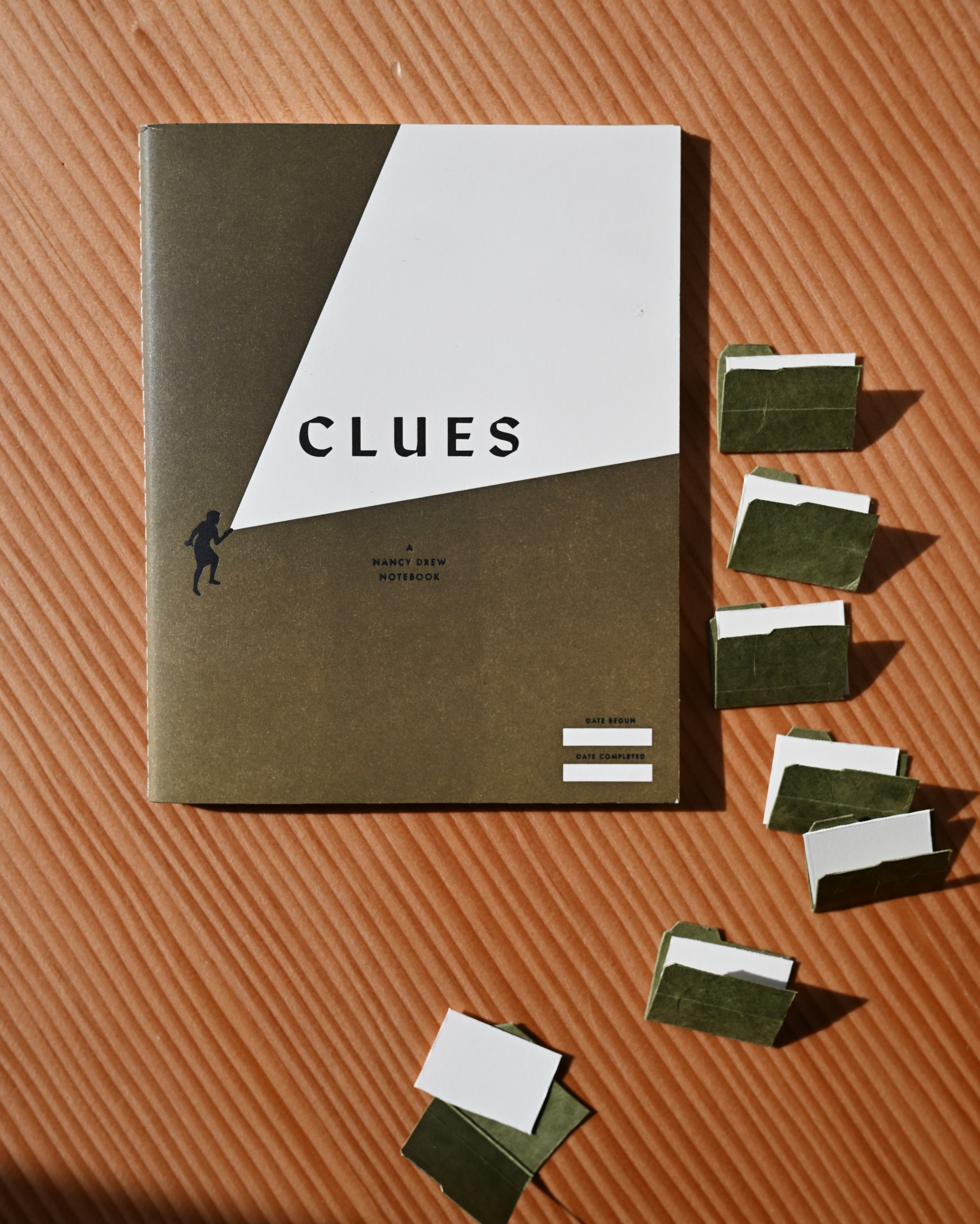 archive green letterpress clues nancy drew notebooks with tiny file folders nearby against douglas fir background